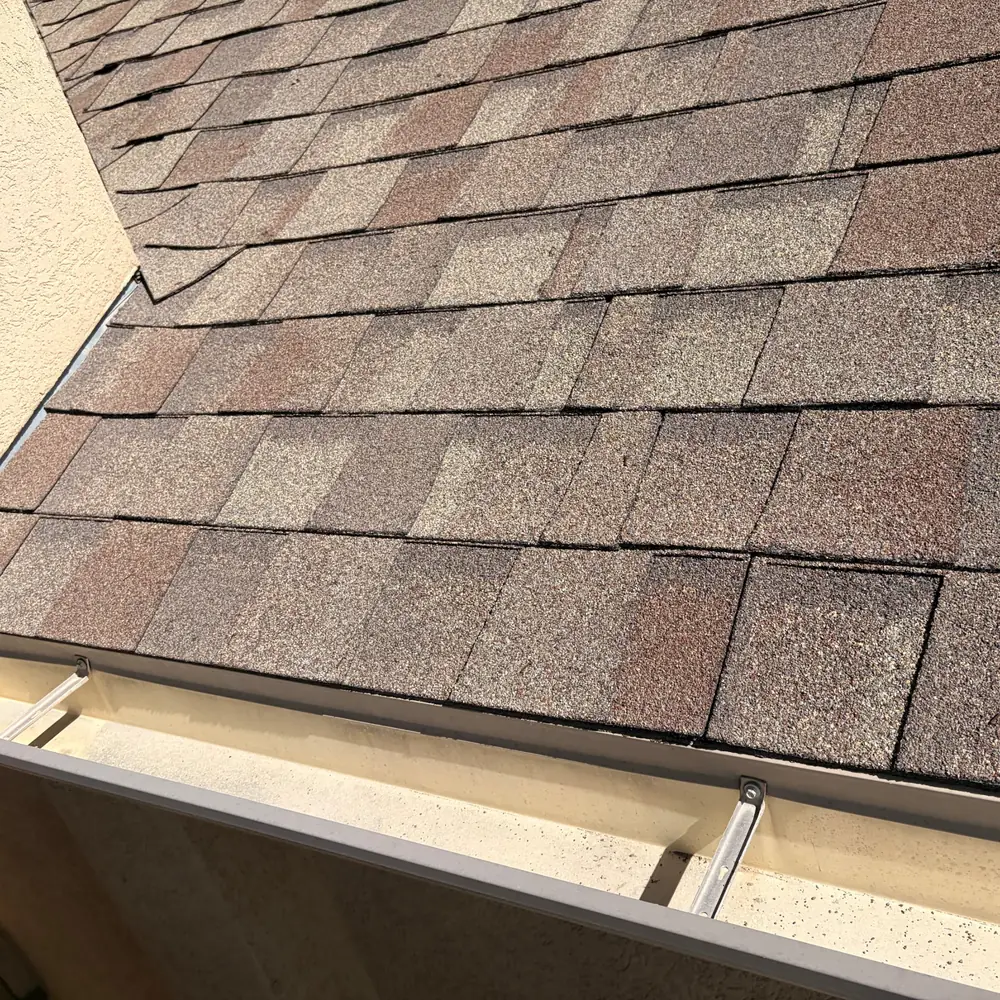 Clean gutter below a roof valley after debris removal
