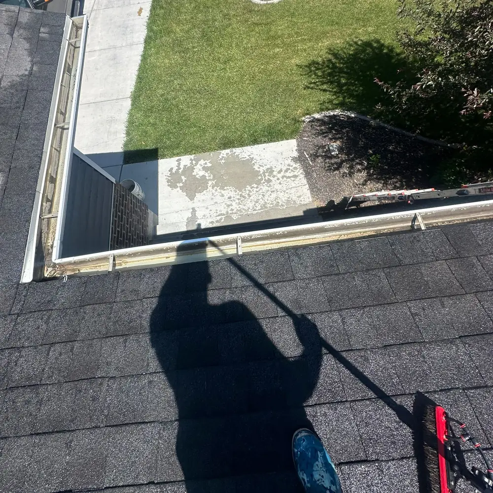 Nice Glass cleaning gutters by hand from the roof of a Utah home