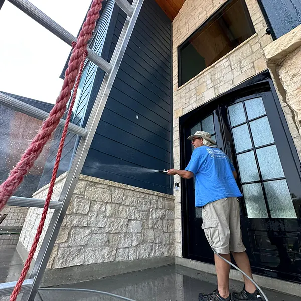 Nice Glass technician rinsing a home entry and glass doors