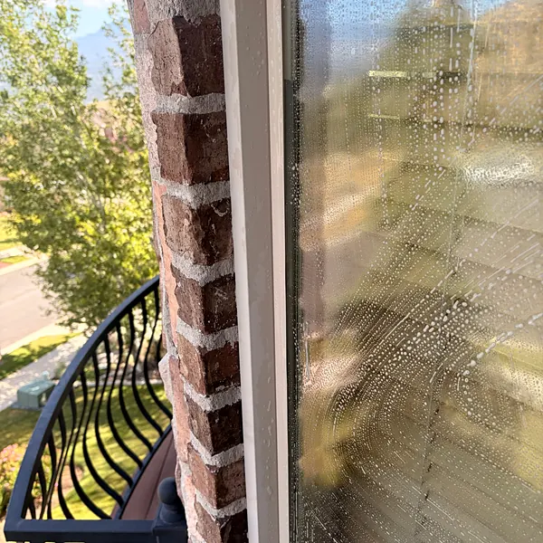 Scrubbing a second-story window during a cleaning