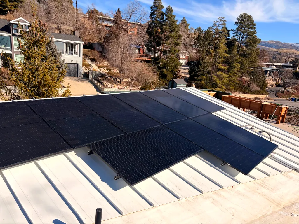 Clean solar panels on a metal roof with mountain views
