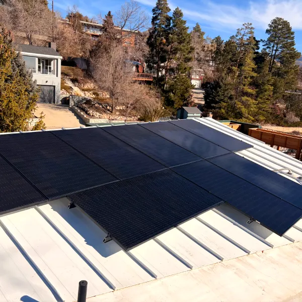 Clean solar panels on a metal roof with mountain views